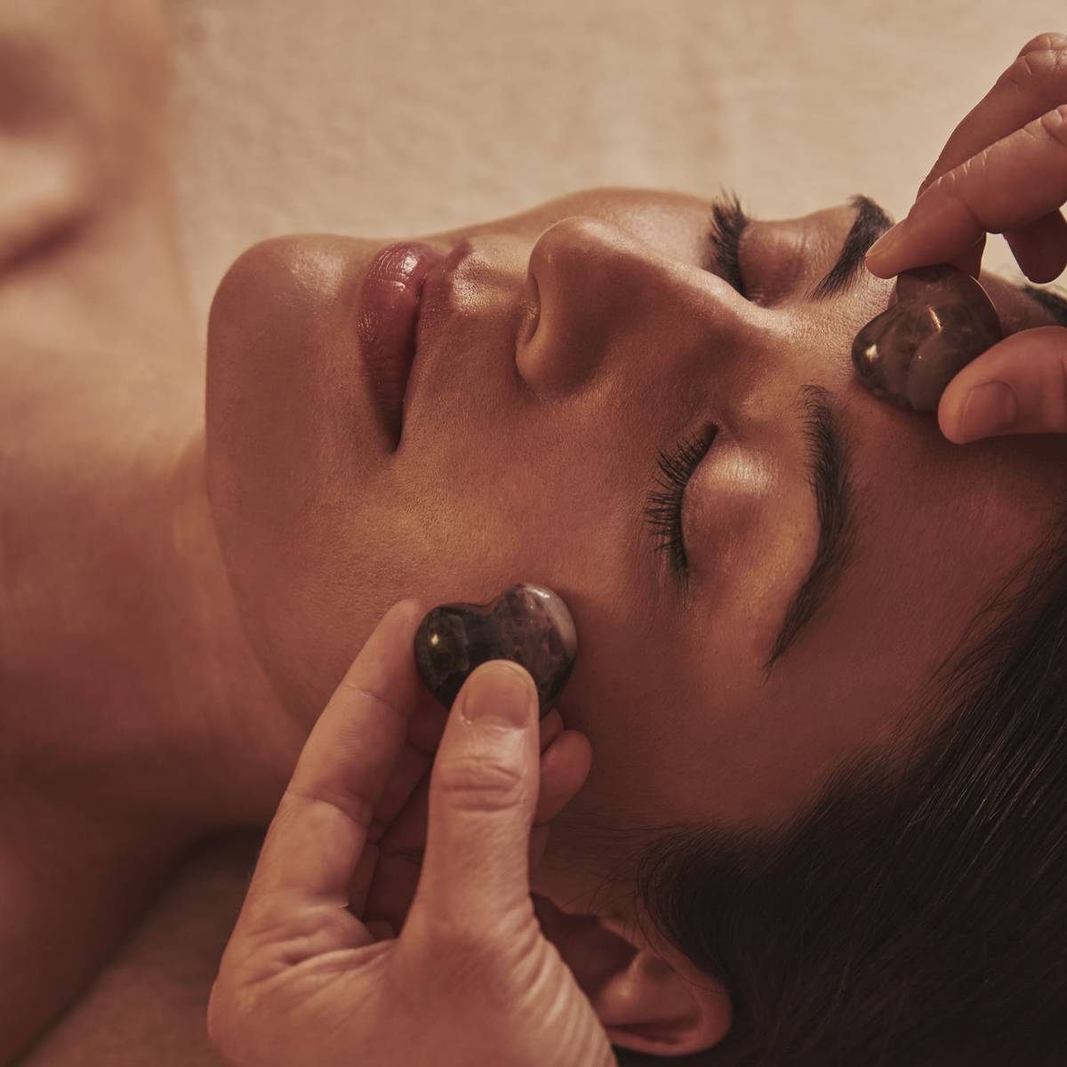 A soothing facial treatment using smooth crystal stones, gently massaging the skin to promote relaxation, balance, and rejuvenation