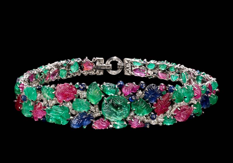 A dazzling Art Deco bracelet with carved emeralds, rubies, sapphires, and diamonds set in platinum.