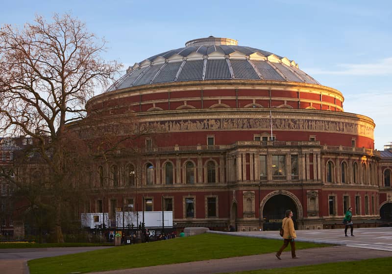 The historic Royal Albert Hall concert hall bathed in golden light, a landmark of London's rich cultural heritage.