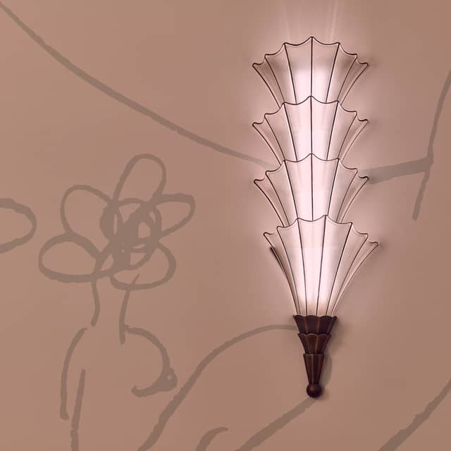 Delicate fan-shaped wall sconce with soft light, accented by abstract floral-inspired wall art.
