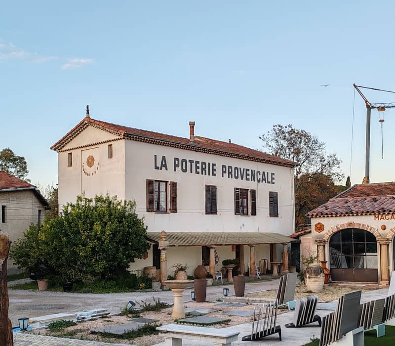 Traditional Provençal pottery shop surrounded by rustic charm, greenery, and a serene countryside ambiance.