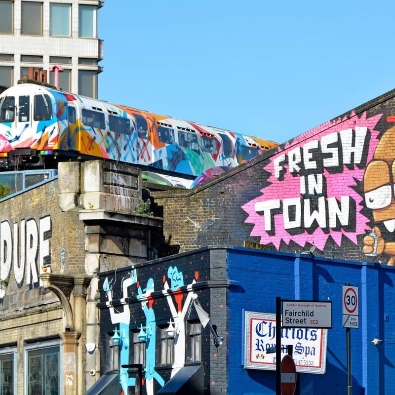 Vibrant street art with graffiti-covered train cars and colorful murals showcasing urban creativity and a dynamic city vibe.