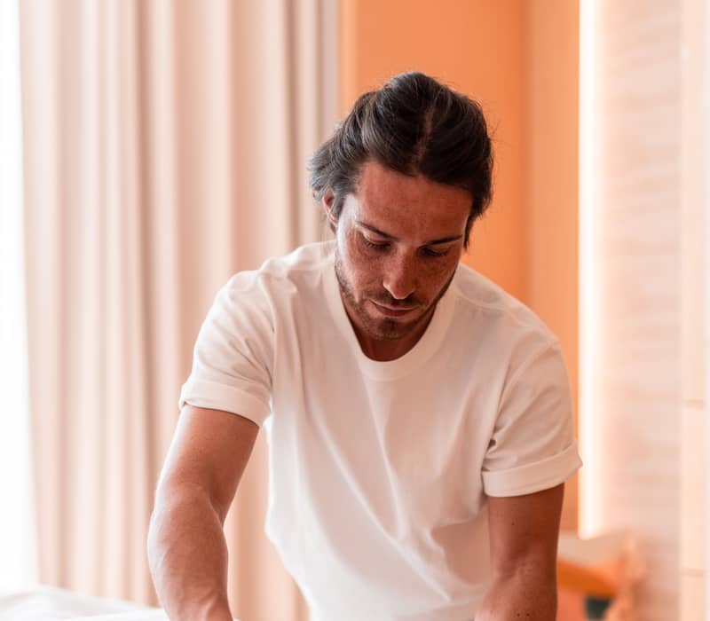 Tranquil spa experience with a skilled therapist providing a soothing massage in a serene, light-filled setting for ultimate relaxation.