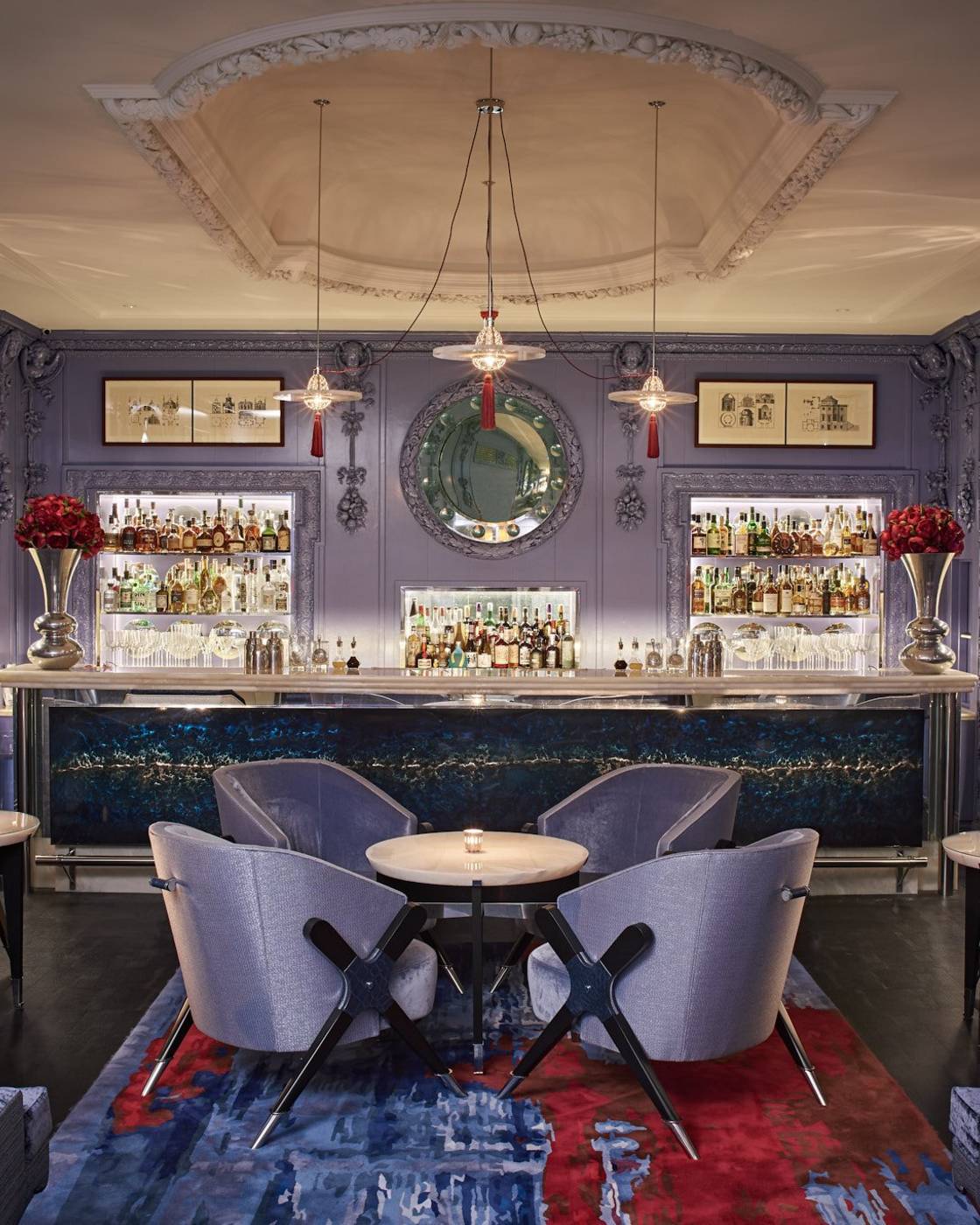 A sophisticated cocktail bar with deep blue hues, plush seating, and an illuminated bar, exuding timeless elegance and intimate glamour.