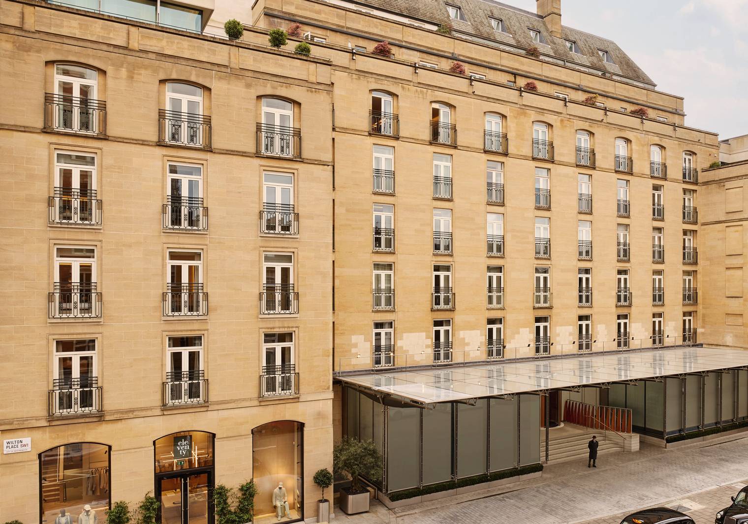 The Berkeley's stately exterior, featuring classic stone architecture, wrought-iron balconies, and a sophisticated entrance with glass canopies in Knightsbridge.
