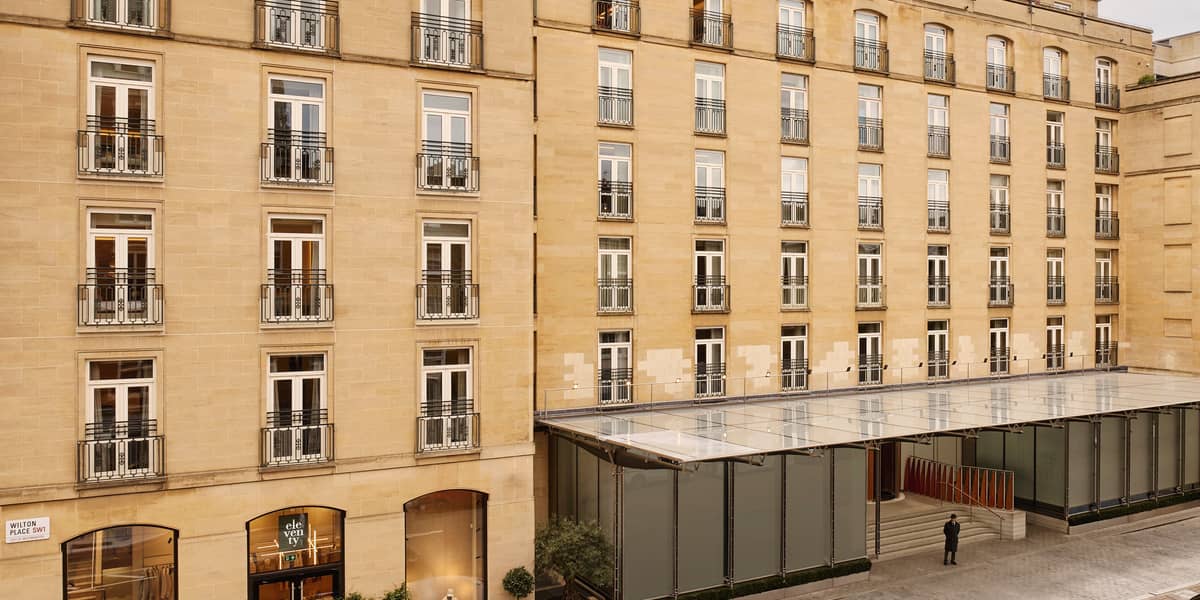 The Berkeley's stately exterior, featuring classic stone architecture, wrought-iron balconies, and a sophisticated entrance with glass canopies in Knightsbridge.