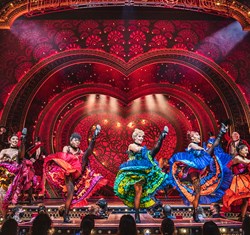 Moulin Rouge! The Musical - Cast dancing in colourful dresses