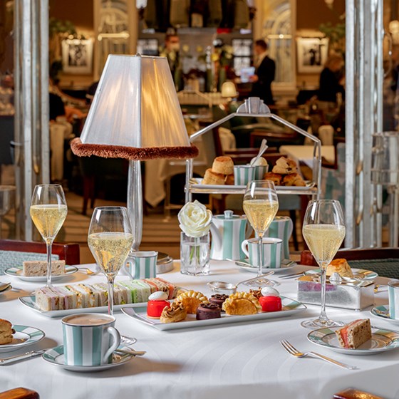 Afternoon tea at Claridges - platter of afternoon tea snacks with champagne glasses.