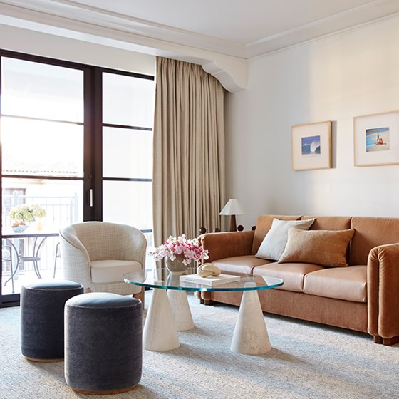 View of a suite at The Maybourne Beverly Hills - lounge with couch, coffee table and armchair.