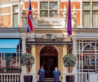 The exterior of The Connaught. With the sign visible and two doormen standing outside the main entrance.