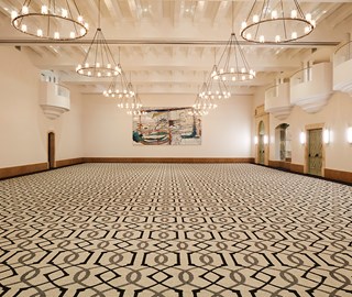 Marquesa room at The Maybourne Beverly Hills -full view of the room with pattern carpet and lights hanging from the ceiling.