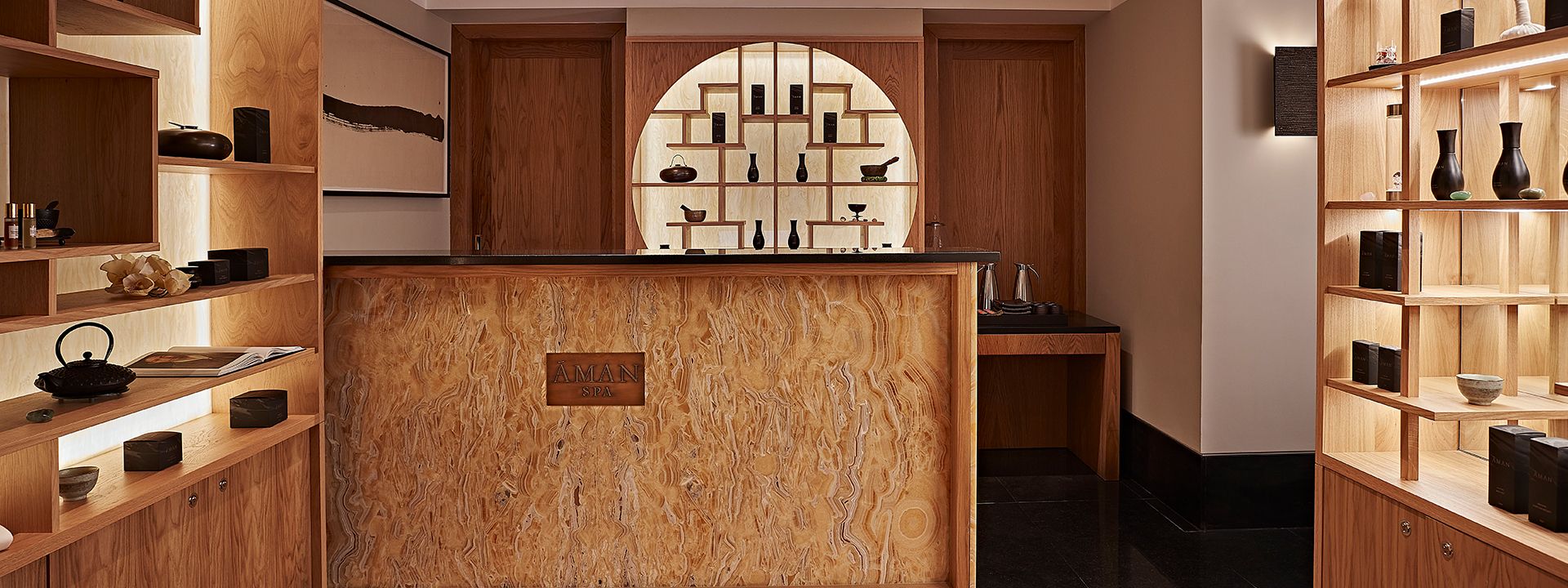 Aman Spa at The Connaught - Spa entrance with counter and cupboards with products on each side of the counter